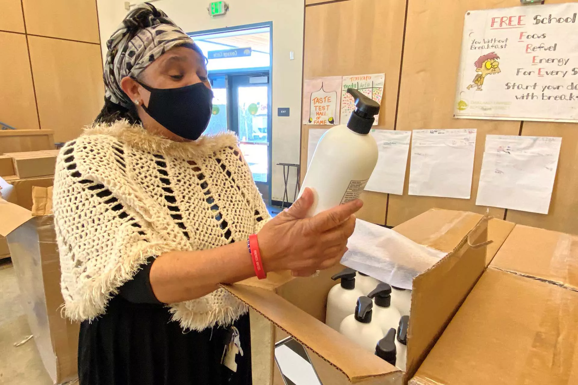 Woman looking at lotion product from a donated box of products