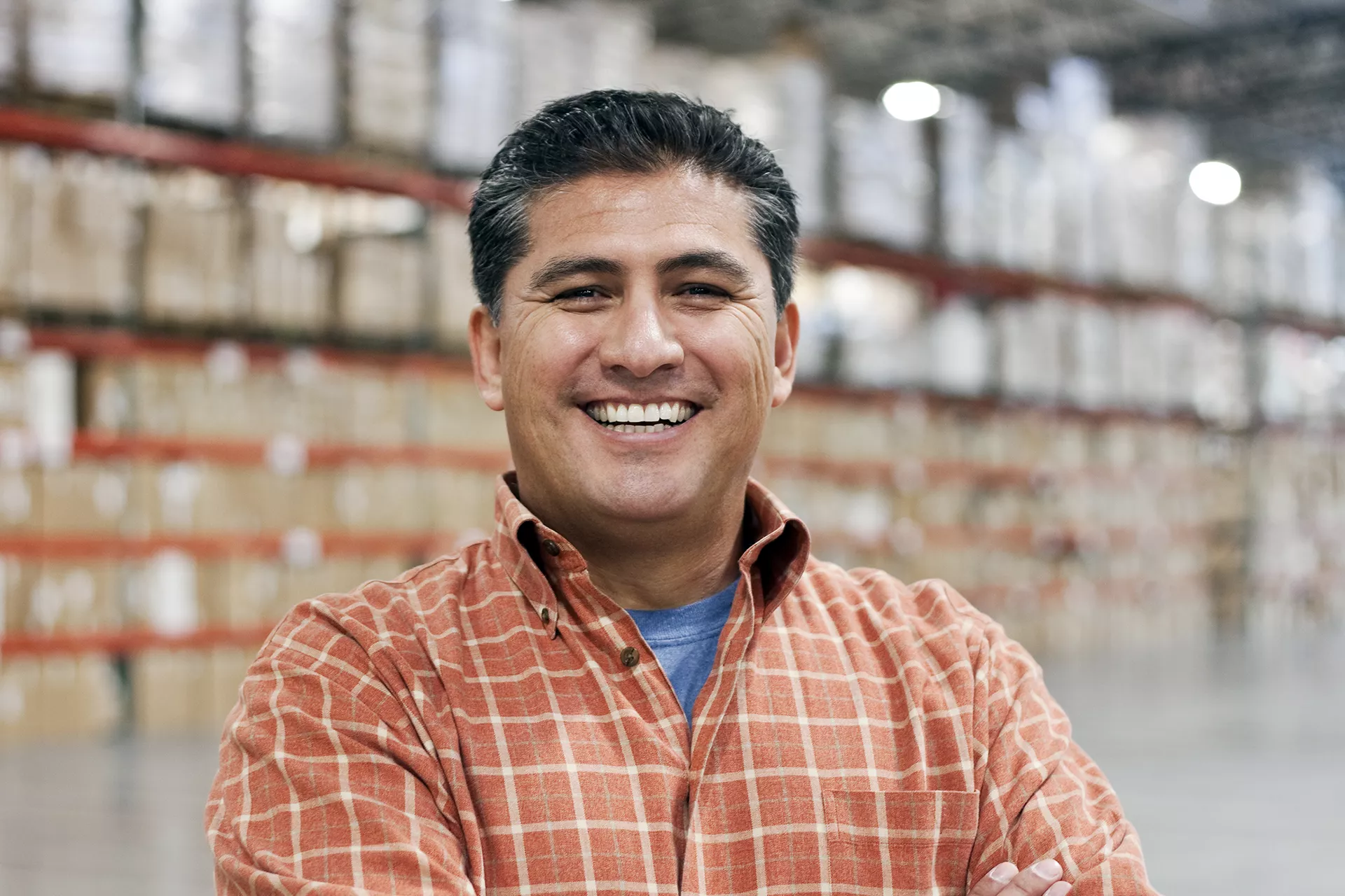 Man smiling and standing on warehouse floor