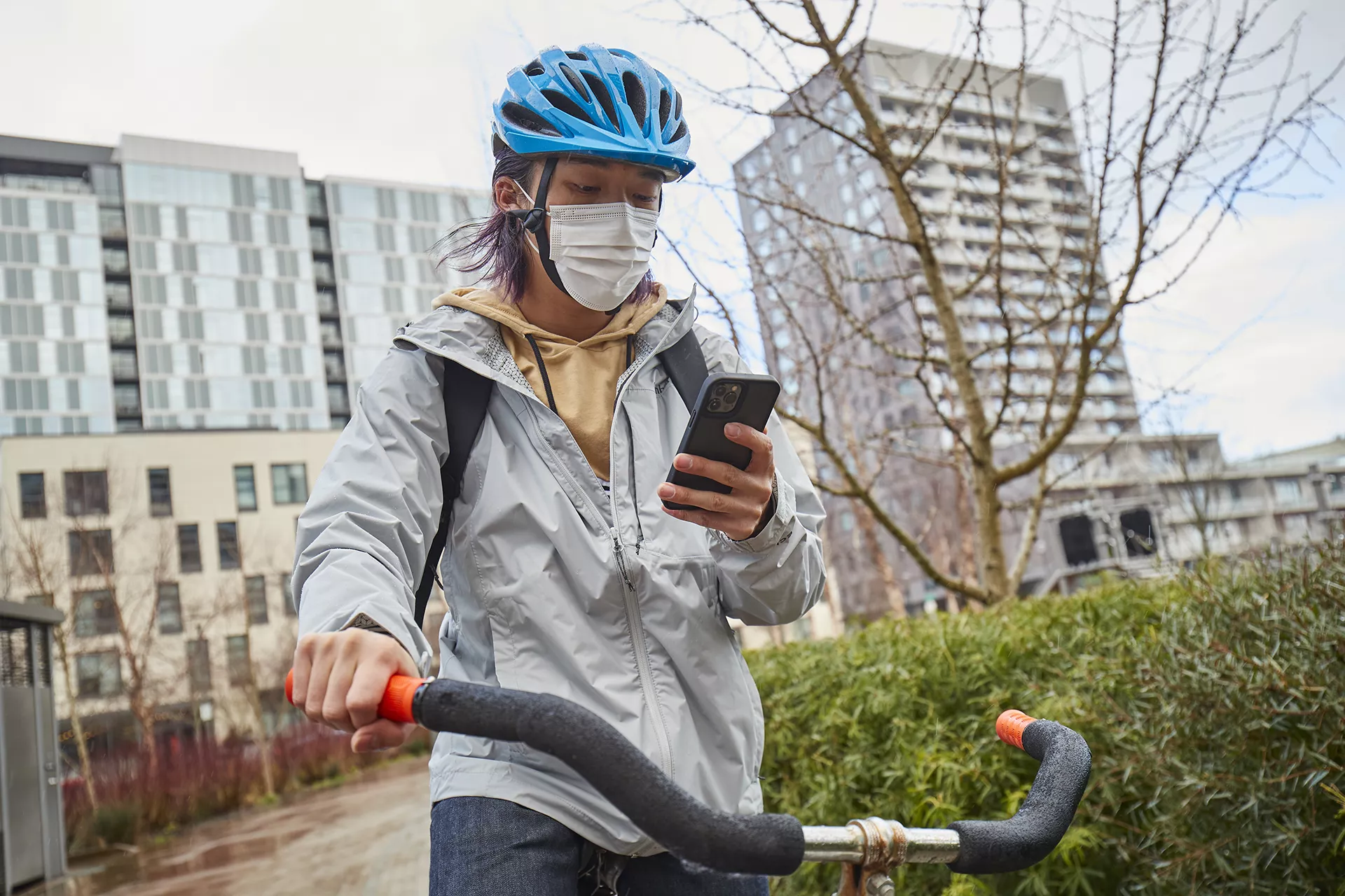 Teen holding bike while looking at phone