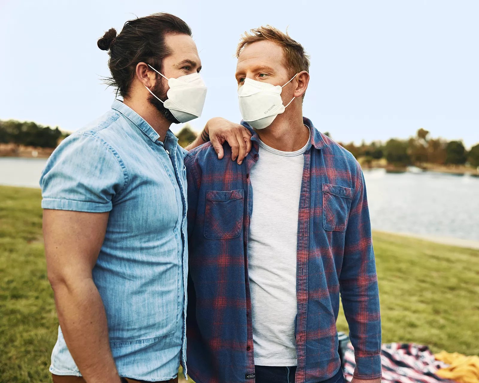 Same sex couple with two men wearing masks outside in a park