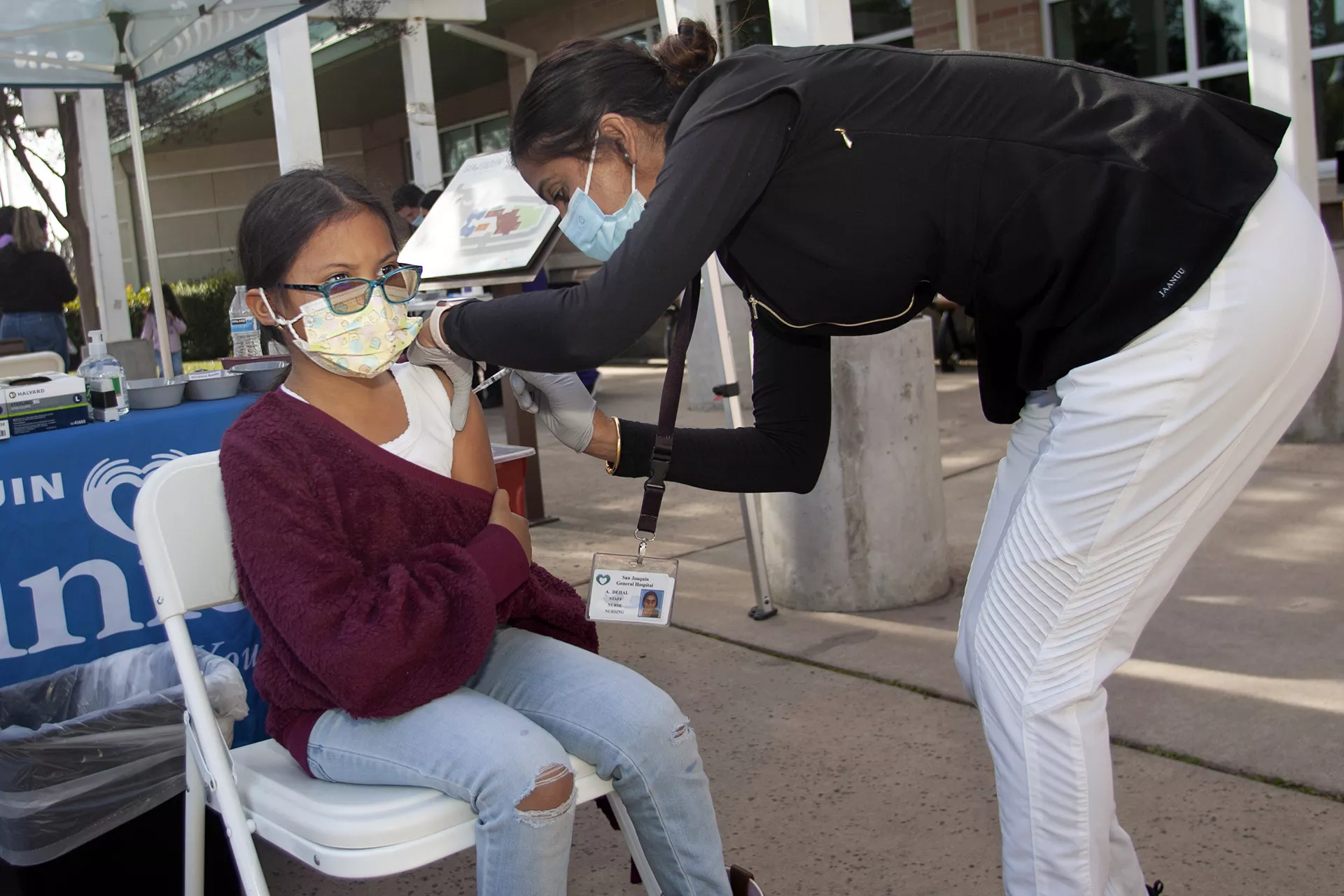 Child getting vaccinated by nurse