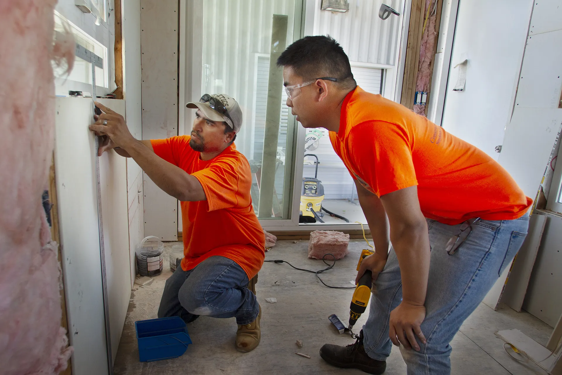Two men working inside newly constructed home